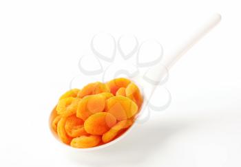 Dried apricots on porcelain spoon