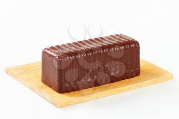 Chocolate-coated loaf cake on cutting board