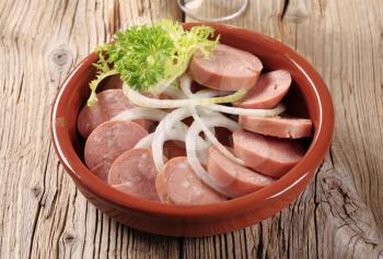 Sliced sausages with rings of fresh onion
