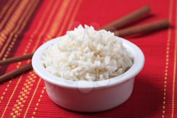 Bowl of white rice and wooden chopsticks