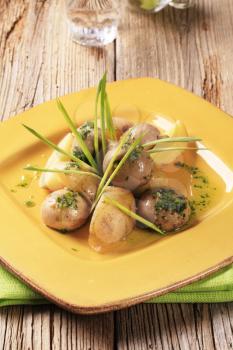 New potatoes and button mushrooms garnished with spring onion