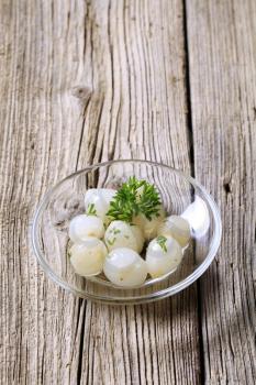 Pickled pearl onions on a glass dish 