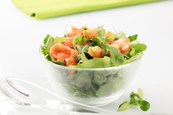Bowl of salad greens with slices of smoked salmon and croutons 