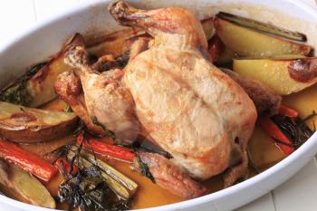 Chicken with potatoes , carrot and celery baked in a casserole dish