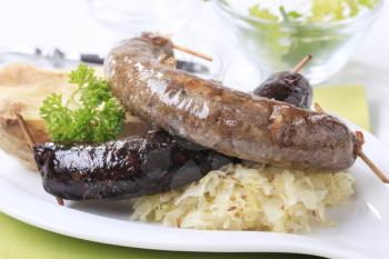 Blood sausage and white pudding with sauerkraut and baked potato