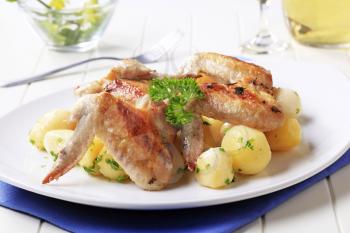 Roasted chicken wings and potatoes - closeup
