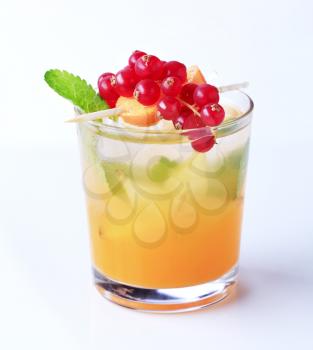 Glass of iced drink garnished with fresh fruit