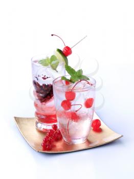 Glasses of iced drinks garnished with fruit