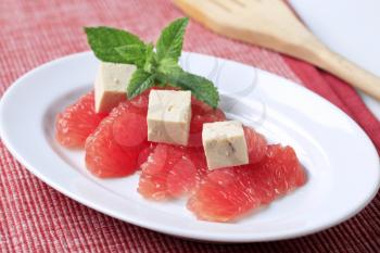 Pieces of red grapefruit and tofu - closeup