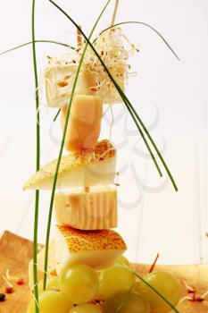 Cheese and pear skewer garnished with sprouts and chives