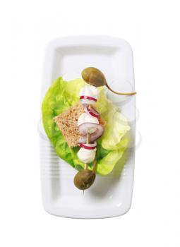 Mozzarella cheese, capers and onion on a wooden skewer