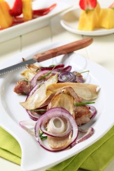 Pan fried pork tenderloin with onion and endive leaves