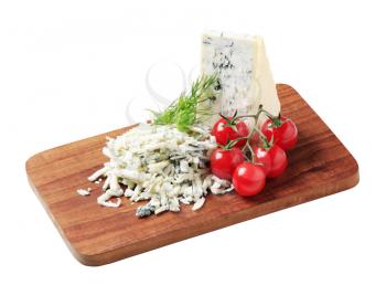 Blue cheese and fresh tomatoes on a cutting board