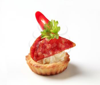 Tartlet shell filled with cheese and salami