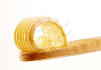 Butter curl on a wooden spoon  - detail