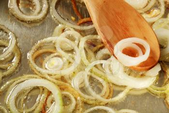 Frying onion rings in a pan - detail