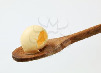 Curl of fresh butter on a wooden spoon