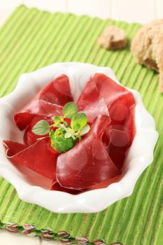 Thin slices of dried meat in a bowl