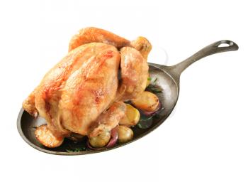 Baked chicken and potatoes on a cast iron skillet