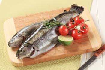 Two fresh trout on a cutting board