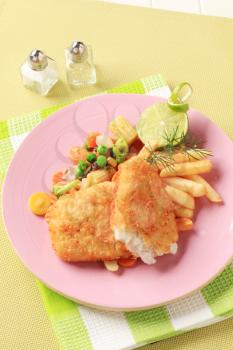 Fried breaded fish fillets with French fries and mixed vegetables