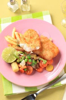 Fried breaded fish fillets with  mixed vegetables and French fries