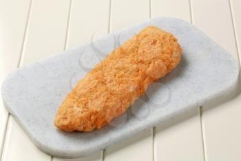 Battered fish fillet on a cutting board