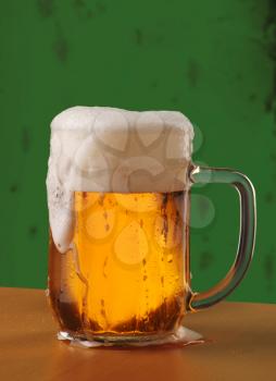 Mug of Freshly Poured Beer with Overflowing Foam Head
