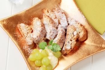 Traditional Italian almond biscotti with grapes and pudding