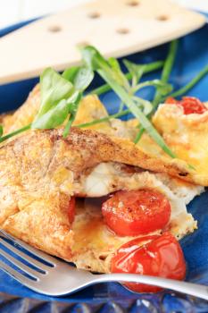 Egg omelet with tomatoes and salad greens