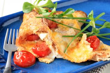 Egg omelet with tomatoes and salad greens