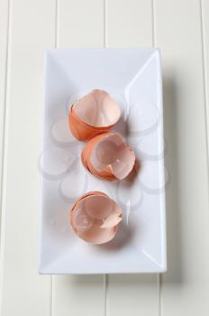 Empty brown egg shells on white dish