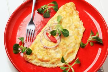 Egg omelet sprinkled with fresh salad greens