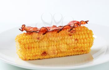 Corn on the cob and rasher of bacon