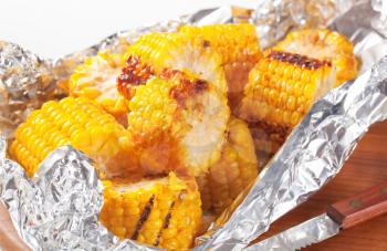 Pieces of grilled sweet corn in tin foil