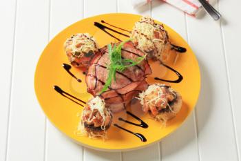 Mushrooms stuffed with ground meat and pork fillet wrapped in bacon