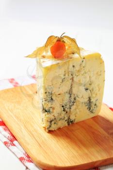 Wedge of blue cheese on cutting board