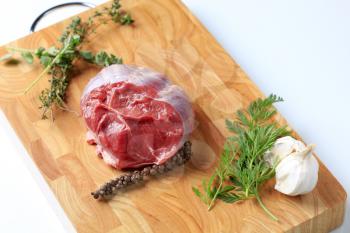 Raw shin beef and herbs on a cutting board
