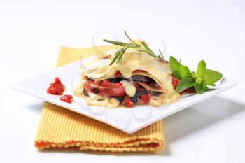 Tomato and aubergine lasagna topped with cheese sauce