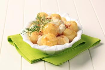 Bowl of pan fried potatoes topped with melted cheese