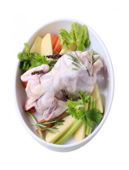 Raw chicken and vegetables in a casserole dish 