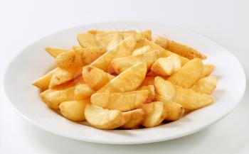 Heap of crispy potato wedges in a plate