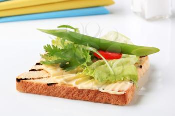 Slice of toasted bread with butter and fresh vegetables