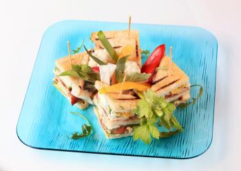 Grilled turkey and bacon sandwiches garnished with fresh vegetables