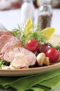 Roast pork tenderloin served with vegetables - detail