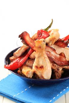 Pan fried pork chop, chicken drumsticks, bacon and red peppers