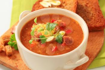 Cup of spicy soup with fried bread