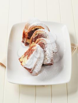 Slices of marble cake sprinkled with icing sugar