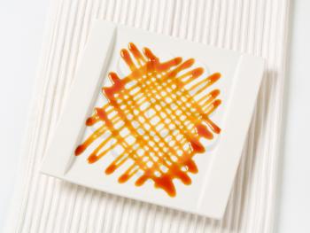 Caramel drizzle sauce decoration on plate