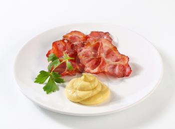 Pan fried bacon slices and mustard sauce